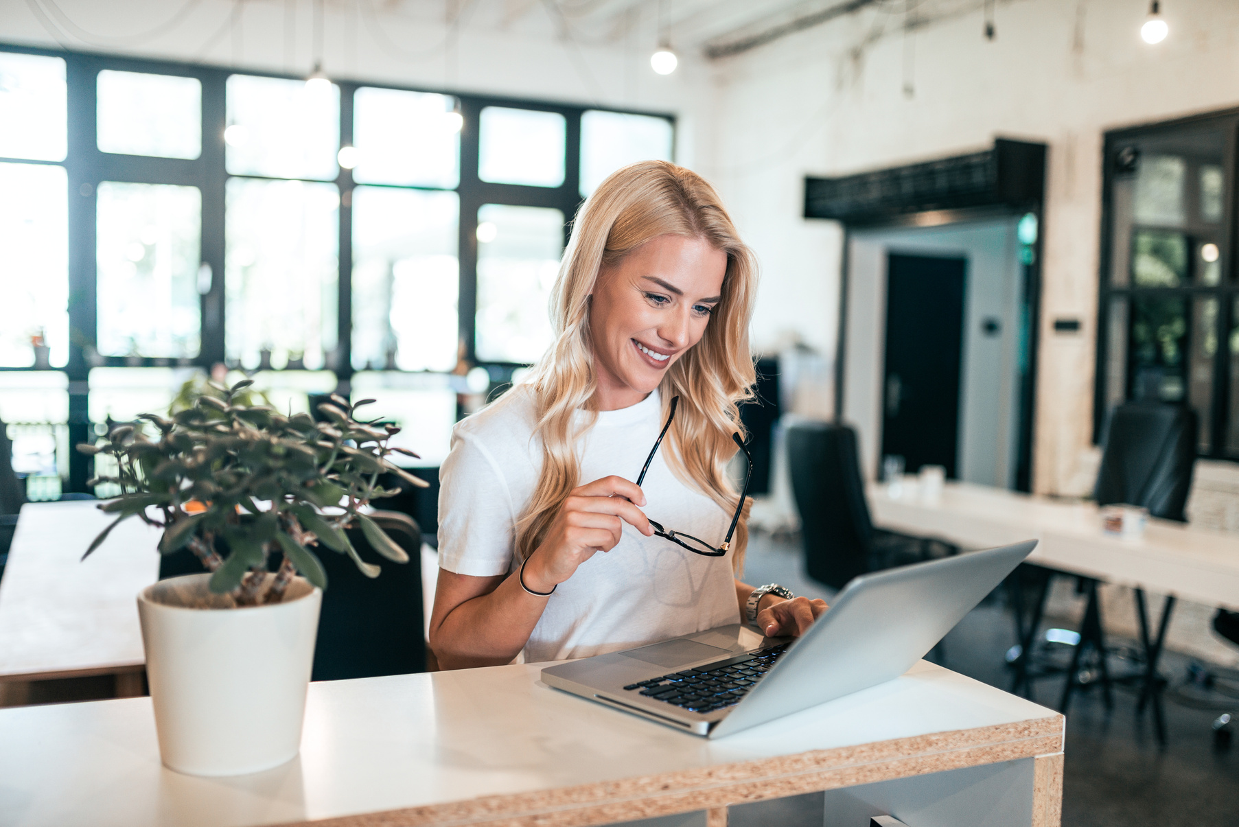 Successful blonde woman using laptop.